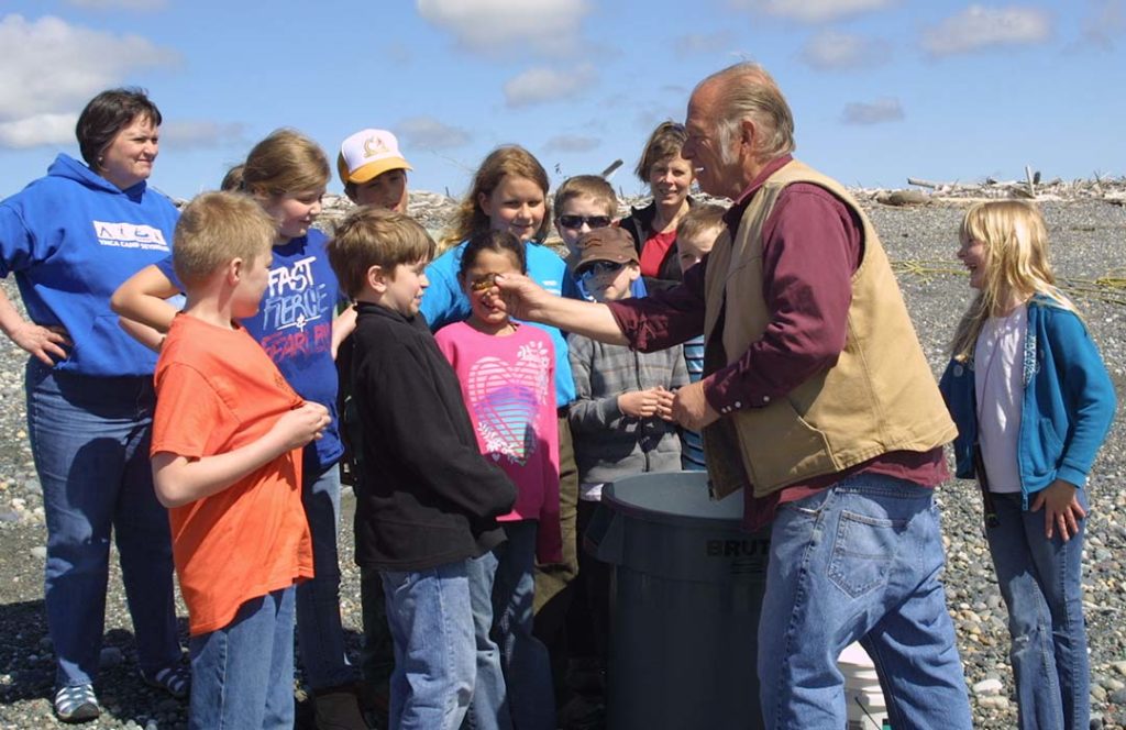 A teacher shows a group of students a sea creature.